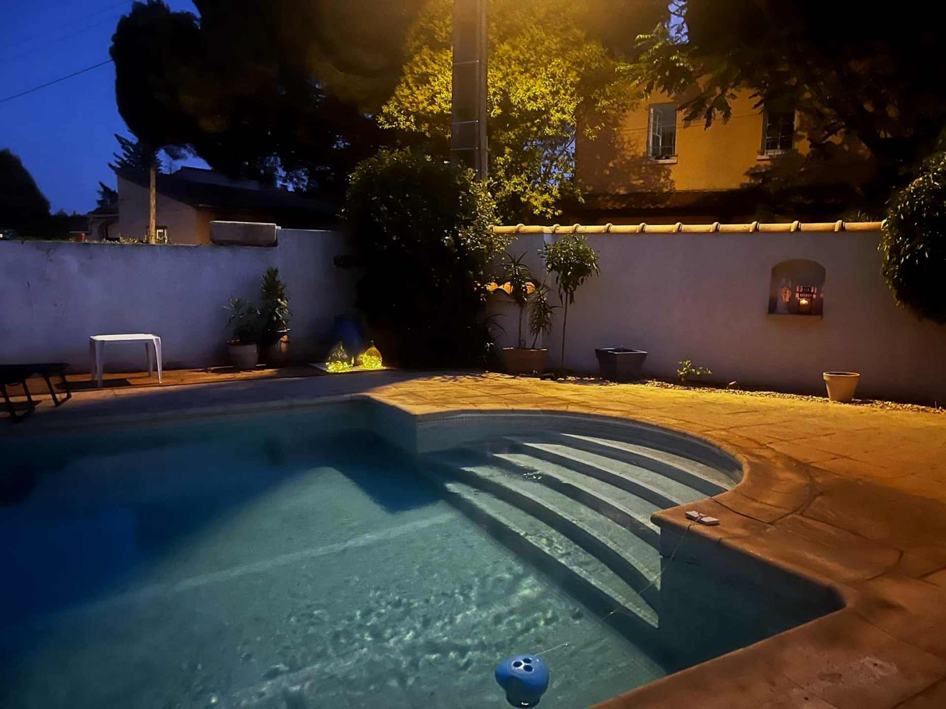 Le jardin et la piscine sous l'éclairage du soir.